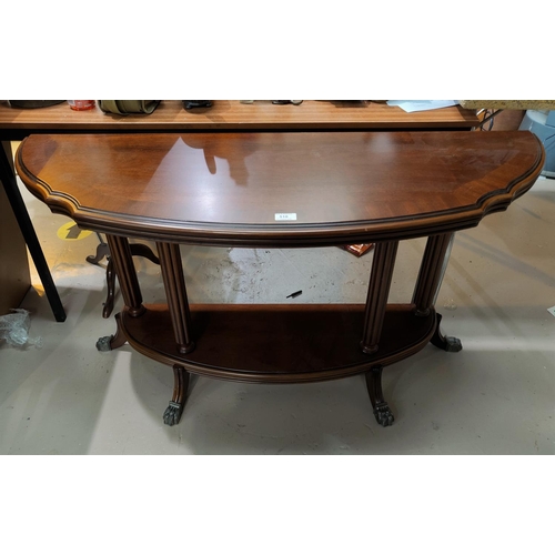510 - A mahogany reproduction 2 tier occasional table with demi-lune top, on paw feet