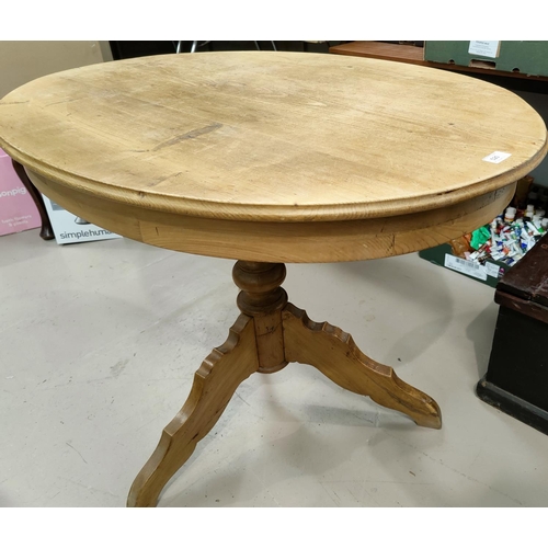 520 - An oval pine pedestal table with two hoop back chairs.