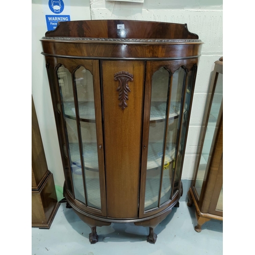568 - A mahogany bow front corner cupboard with double glazed doors on ball and claw feet