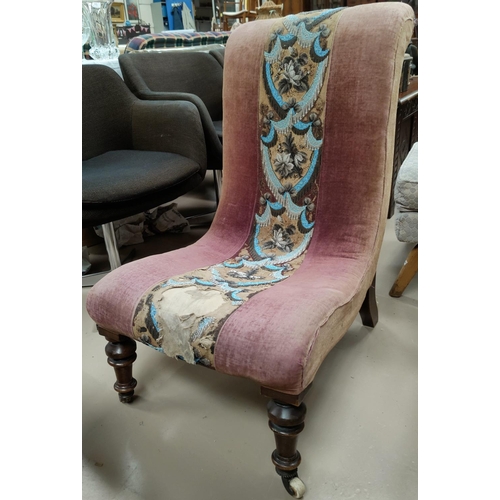 574 - A Victorian scoop back nursing chair with central beaded decoration, on turned legs.