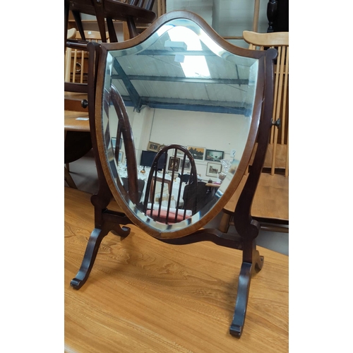581 - A free standing dress table mirror in shield shaped frame