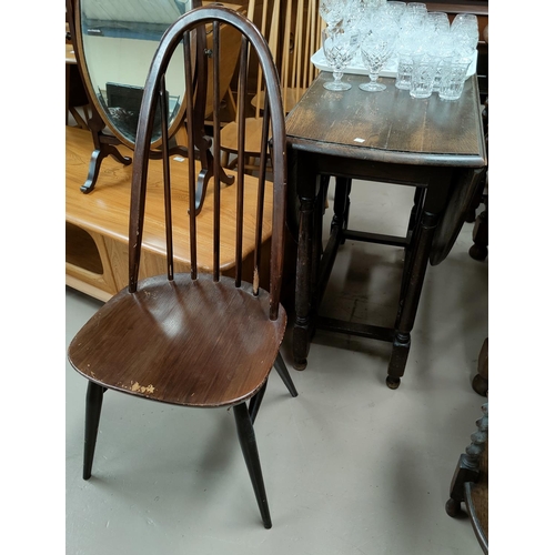 630 - A 1930's oak drop leaf dining table with oval top; 4 Ercol hoop and stick back chairs