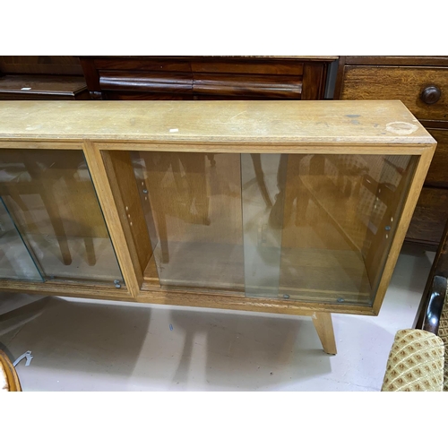 636 - A 1950's pale oak bookcase, sliding glass doors 152cm