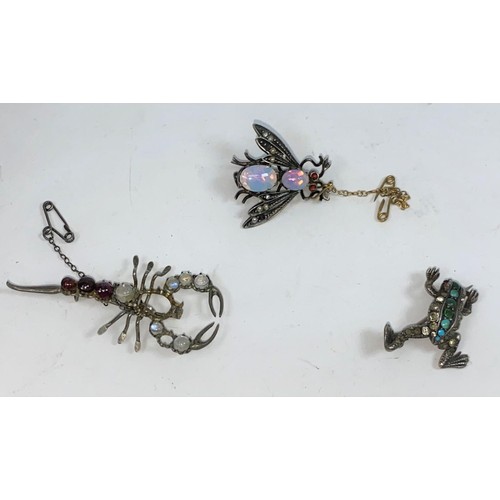 395 - Three novelty brooches set with various stones - a fly with opal effect body and red eyes, a scorpio... 