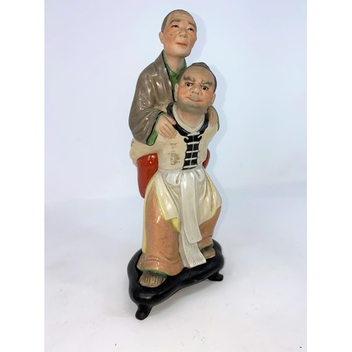 286 - A Chinese ceramic group , son carrying mother on his back (some areas of damage) on wooden stand (a.... 