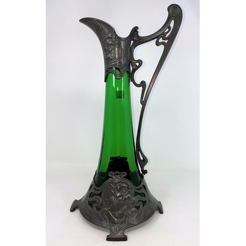 323 - An Art Nouveau green glass wine jug of swelling form, the pewter mounts with embossed decoration sta... 