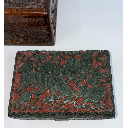 291A - A Chinese cinnabar and black colour lidded box decorated with temple dogs and another carved wooden ... 