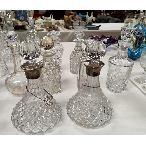 212 - A pair of cut crystal ships decanters with silver rims; 6 other decanters