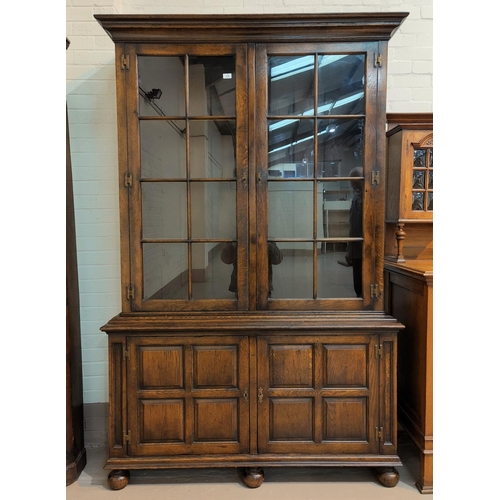488 - An 18th century style distressed oak bookcase/cabinet in the manner of Titchmarsh & Goodwin, the upp... 