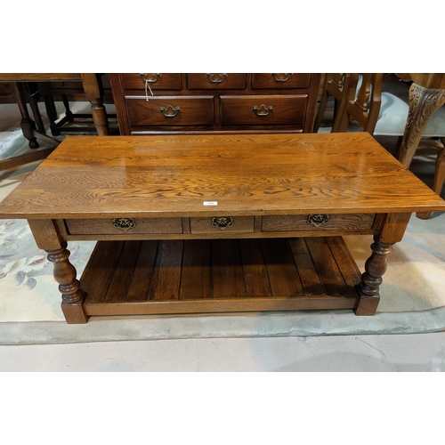 645 - A reproduction oak two tier coffee table with drawers.