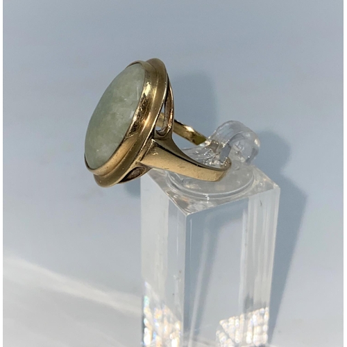 369 - A 9 carat hallmarked gold dress ring set with oval jade coloured stone, size O1/2, 6.3gm