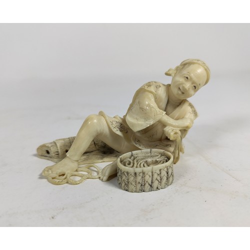 302 - A late 19th/early 20th Century Japanese ivory Okimono depicting a man reclining coiling rope, small ... 