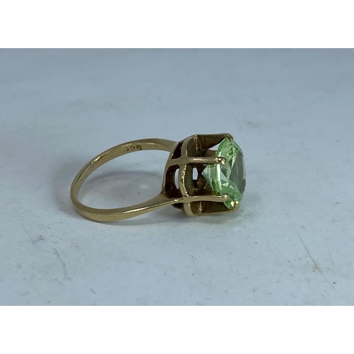 373 - A yellow metal dress ring  with citrine / peridot type stone in raised setting, tests as 9 ct, size ... 