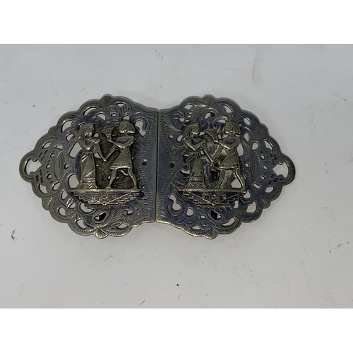 402 - A hallmarked silver pair of dwarf candlesticks; a nurse's silver plated buckle with Egyptian decorat... 