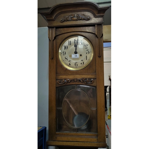 106 - An Arts & Crafts wall clock, with strike, in carved oak case