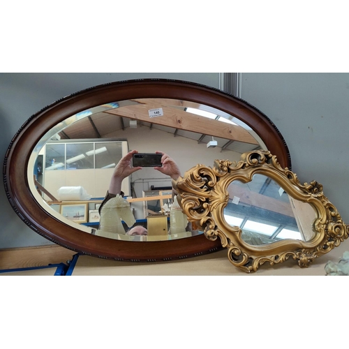 140 - A 1920's oval wall mirror in mahogany frame; 2 others