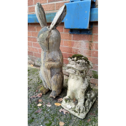25 - A garden 'Temple Dog' in reconstituted stone; a wooden rabbit