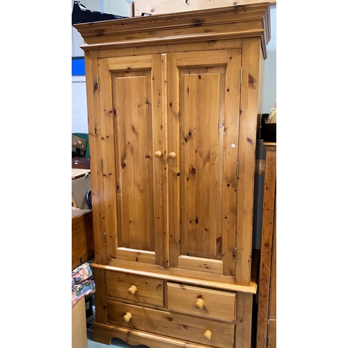 526 - A modern pine double door wardrobe enclosed by two paneled doors with base draw