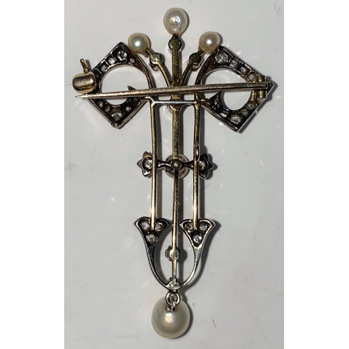332a - A Belle Epoque diamond and pearl yellow and white metal brooch with central stem and twin scroll arm... 