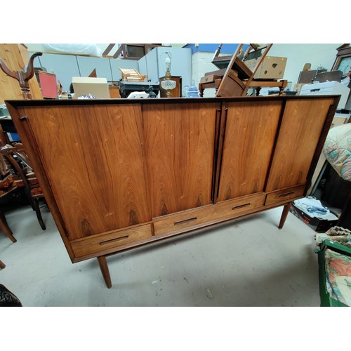 482 - A 1960's Danish Rosewood high sideboard with shelves enclosed by four sliding doors, 3 drawers under... 