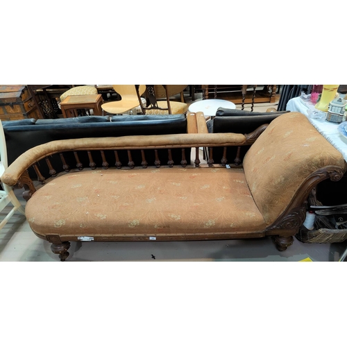 484 - A Victorian golden oak chaise longue with carved back rail and studded turned column decoration