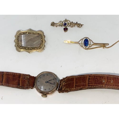 314 - A  1930's ladies 9 carat hallmarked gold wristwatch on leather strap; 2 
Edwardian yellow metal bar ... 