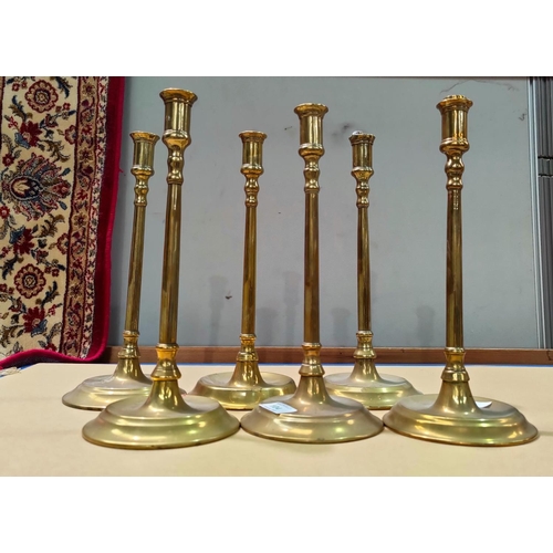 104 - Three early 19th century pairs of brass candlesticks of tall slender form