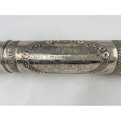 312 - An Indian white metal scroll tube with decoration in relief and with presentation inscription to the... 