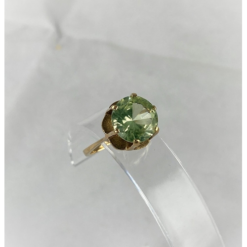 373 - A yellow metal dress ring with citrine/peridot type stone in raised setting, tests as 9 ct, size N