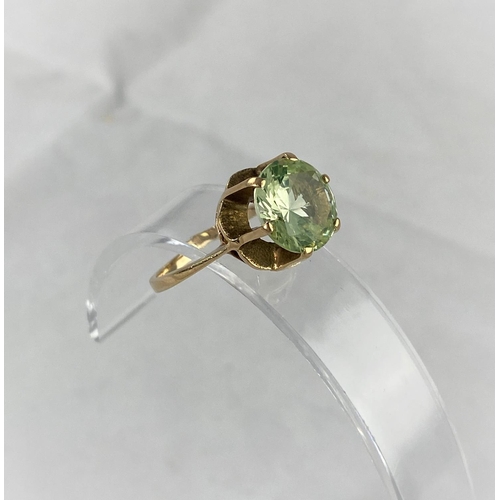 373 - A yellow metal dress ring with citrine/peridot type stone in raised setting, tests as 9 ct, size N