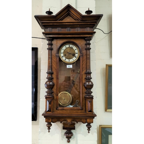 488 - A 19th century Vienna wall clock in walnut case with architectural pediment and half turned side col... 