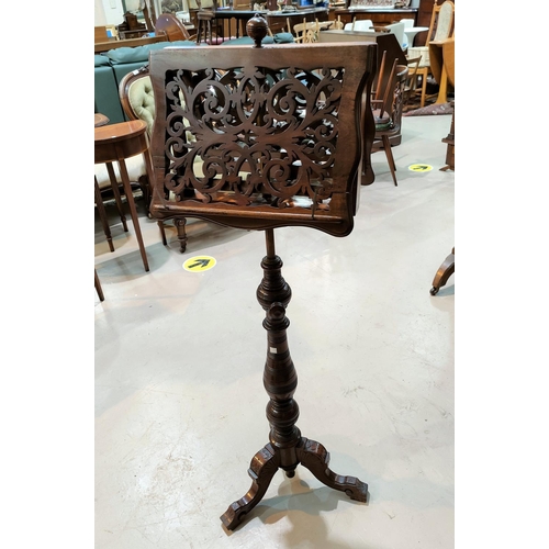 671 - A 19th century fretwork adjustable double sided music stand, on turned baluster column and triple sp... 