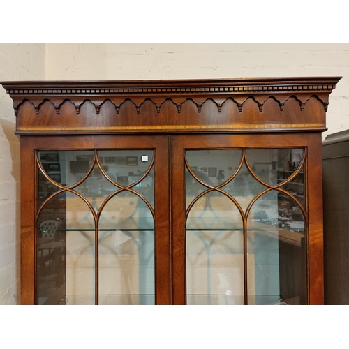 679 - A Georgian style crossbanded mahogany full height bookcase with twin glazed doors over double cupboa... 