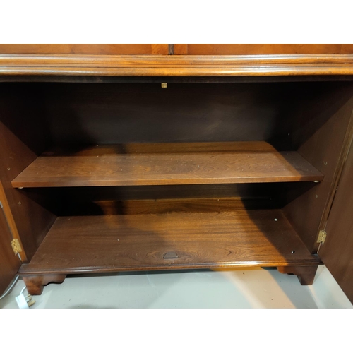 679 - A Georgian style crossbanded mahogany full height bookcase with twin glazed doors over double cupboa... 