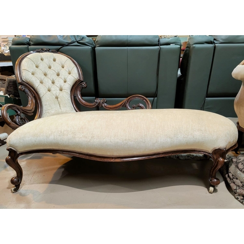 684 - A Victorian carved walnut chaise longue with spoon and pierced scroll back, upholstered in cream dra... 