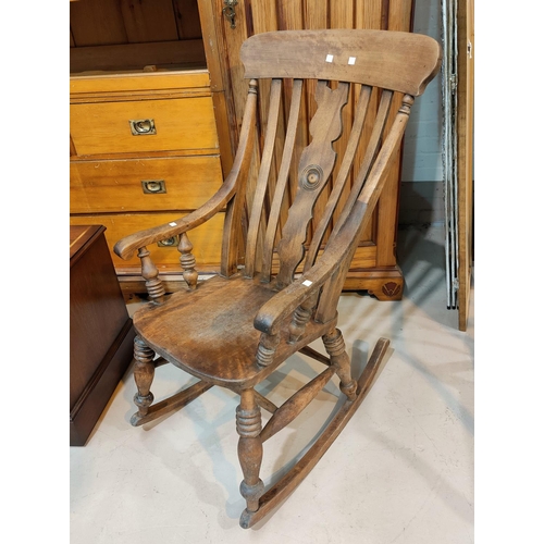 685A - A stained wood rocking chair with lath back