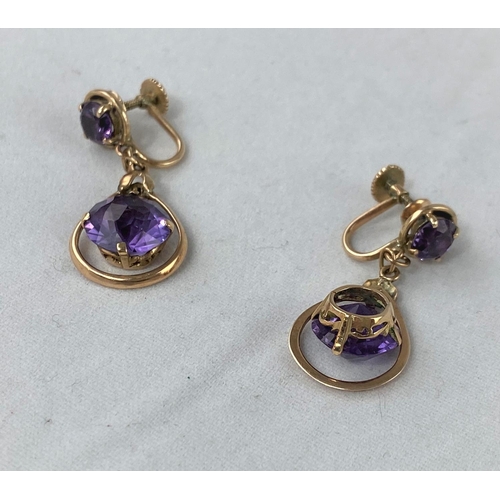 302 - A pair of yellow metal earrings test 14ct comprising of an amethyst with larger round amethyst in sw... 