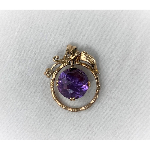 303 - A yellow metal pendant with large round amethyst in swinging circular mount (to match earrings in pr... 