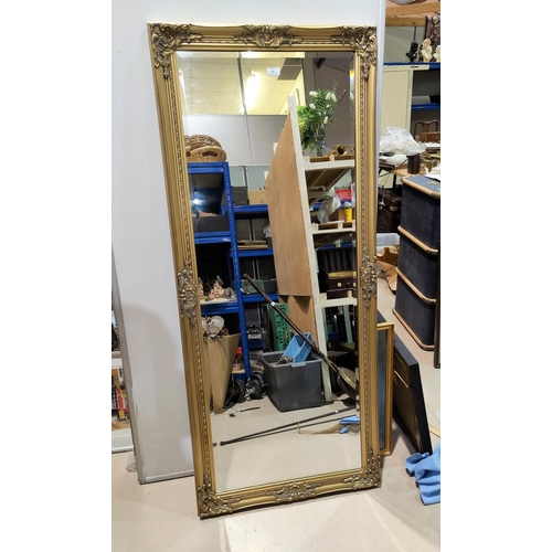 58 - A full length wall mirror in rectangular gilt frame; an oval wall mirror