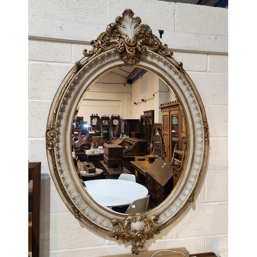 667 - A large Georgian style wall mirror in gilt metal and marble effect ornate oval frame