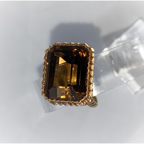 343 - A 1970's yellow metal dress ring with ribbed decoration, set large cushion cut smoky quartz, 11 gm, ... 