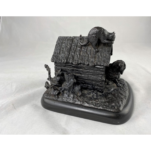 434 - A bronze 19th century style pen and ink stand in the form of a dog kennel with cat on roof, length 7... 