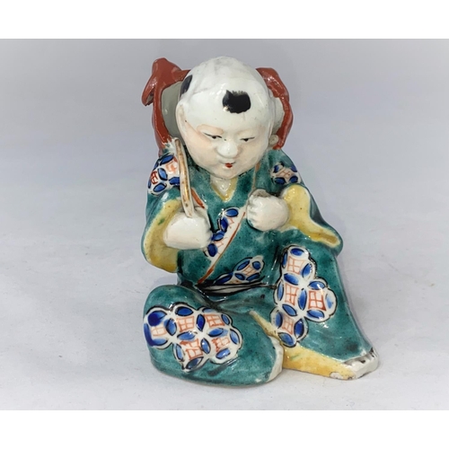 161 - A Chinese porcelain figure depicting a seated man in green robe with lion mask on his back, height 1... 