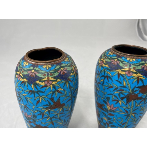 165 - A Chinese pair of ovoid cloisonné vases, naturalistic decoration on blue ground raised on 3 angled f... 