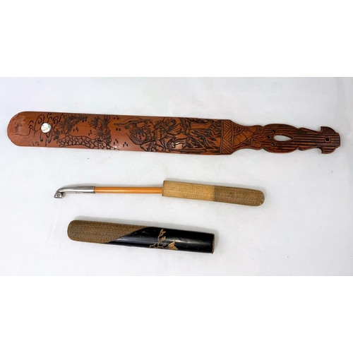 170A - An oriental bamboo pipe with white metal mounts with lacquer and woven pipe case; a carved bamboo pa... 