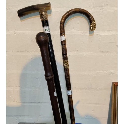 111 - A 19th century ebony walking stick; a similar bamboo cane; a constabulary nightstick