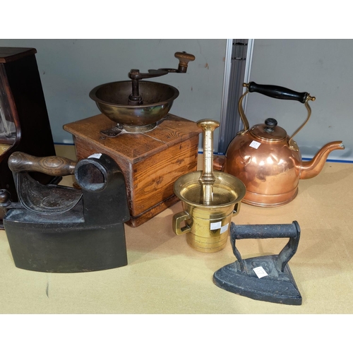 137 - A vintage coffee grinder; a 19th century pestle and mortar 2 irons; a copper kettle