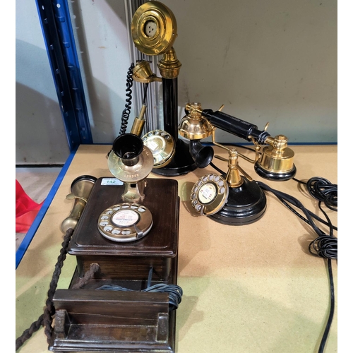 142 - A vintage style wall mounted telephone in brass and wood, 33 cm; a similar stick telephone; another ... 
