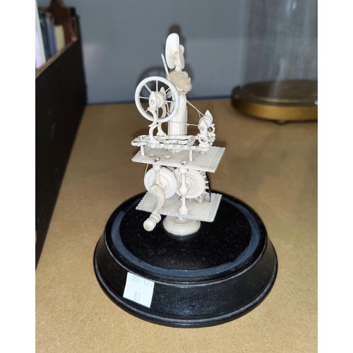 81 - A carved bone miniature group of a woman spinning, under glass dome, height 14 cm (reputedly Napoleo... 