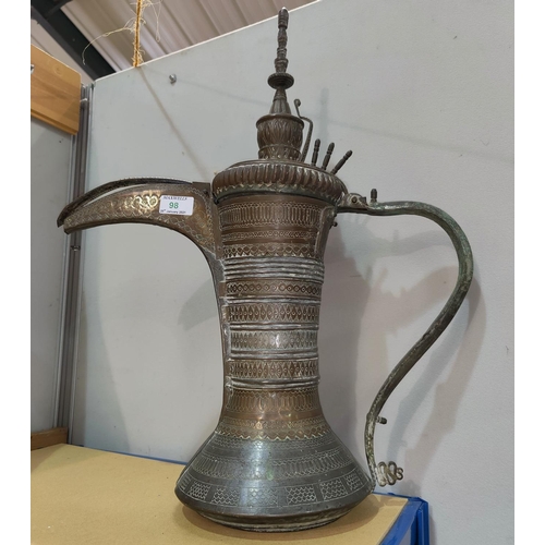 98 - A Middle Eastern brass coffee pot of waisted form, with extensive pierced and engraved decoration, o... 